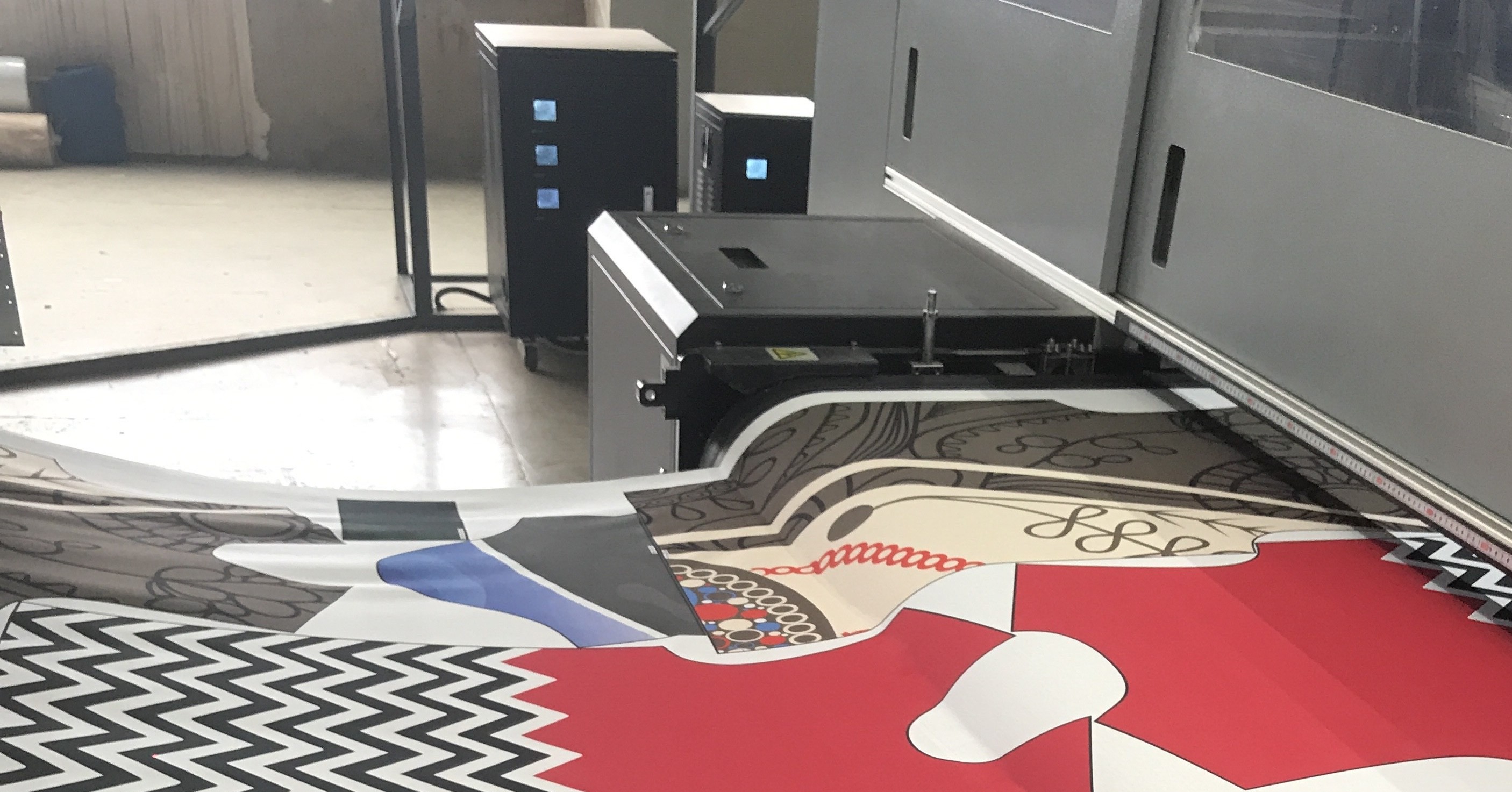Printed cotton coming off the press with garment panels nested across the fabric, ready to be cut